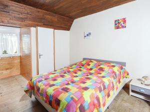 a bedroom with a bed with a colorful comforter at Dordogne Family Haven in Orliac
