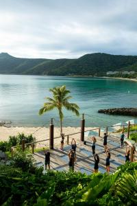 a group of people standing on a dock near the beach at The Sundays in Hamilton Island