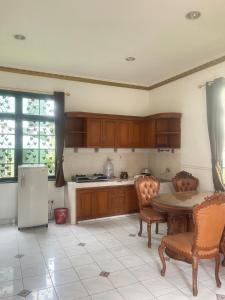 a kitchen with a table and chairs and a refrigerator at Kota bunga in Cikundul
