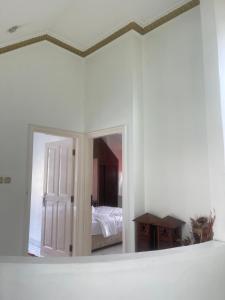 a mirror in a room with a bed and a bedroom at Kota bunga in Cikundul +2 photos