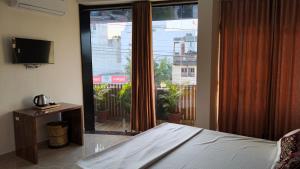a bedroom with a bed and a large glass window at Hotel Times Stay in Udaipur