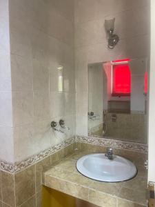 a bathroom with a sink and a mirror at Kota bunga in Cikundul