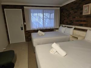 a hotel room with two beds and a window at Best Western Parkside Motor Inn in Coffs Harbour