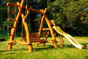 a playground with a swing and a slide at Audrones sodyba in Šventoji