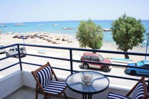 a balcony with a table and chairs and a beach at Rodos Beach in Archangelos
