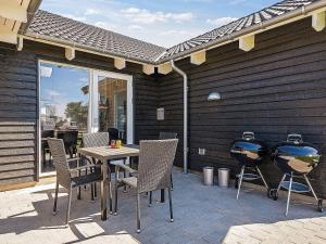 een terras met een tafel en twee barbecues bij 16 person holiday home in Hasselberg in Kappeln