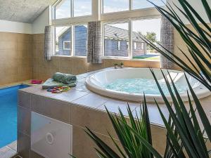 een grote badkamer met een bad en een potplant bij 16 person holiday home in Hasselberg in Kappeln +11 foto's