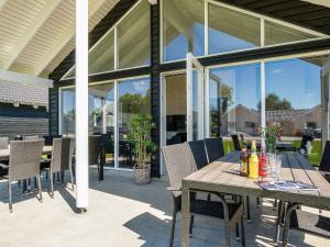een tafel en stoelen op een patio met glazen deuren bij 16 person holiday home in Hasselberg in Kappeln