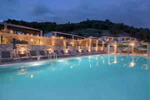 a view of a swimming pool at night at Elimnion Resort in Khrónia