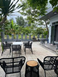 a patio with tables and chairs and a table and chairs at Suoi Da Villa  +10 photos