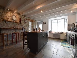 Quiet Normandy Retreat في Saint-Rémy-des-Landes: مطبخ مع كونتر وجدار من الطوب