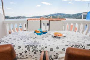 a table with two plates of food on a balcony at Hana Home - Apartments Tisno in Tisno