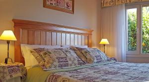 una camera da letto con un letto con cuscini e due lampade di El Nautico Lodge Bariloche a San Carlos de Bariloche