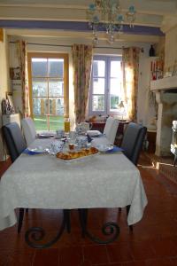 una mesa de comedor con un mantel blanco. en Chambre d'hote Le sablonnet en Ciran