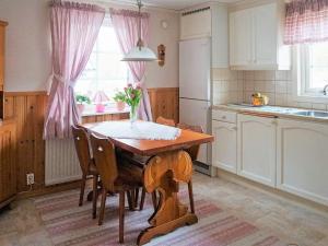 a kitchen with a table with a vase of flowers on it at 6 person holiday home in Trollhättan in Trollhättan +33 photos