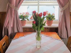 a vase of flowers on a table with flowers in a window at 6 person holiday home in Trollhättan in Trollhättan