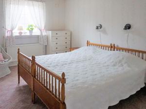 a bedroom with a large white bed with a dresser and a window at 6 person holiday home in Trollhättan in Trollhättan