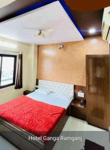 a bedroom with a bed with a red blanket at Hotel ganga in Ajmer