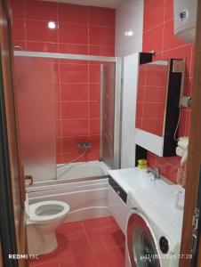 a red bathroom with a toilet and a sink at Bus Station Flat 32 in Prizren
