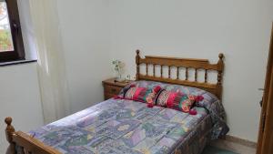 a bedroom with a bed with a comforter on it at La Guaja vivienda de uso turístico in Olleros de Sabero