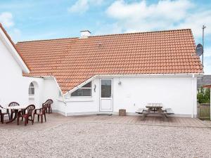 a white building with chairs and a picnic table at 10 person holiday home in Thisted-By Traum in Klitmøller
