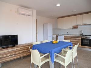 a kitchen with a table with chairs and a blue table cloth at Holiday Home in Korcula with Sea View in Zavalatica