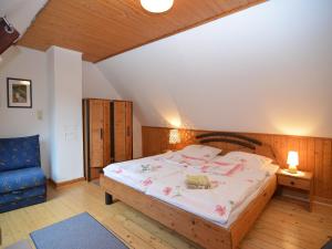 a bedroom with a bed and a blue chair at Holiday home in Ramsbeck with garden in Ramsbeck