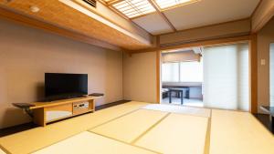 an empty living room with a flat screen tv at Atami Season Hotel in Atami