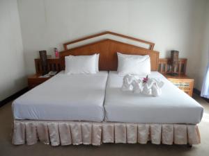 Un dormitorio con una cama con zapatos blancos. en Baiyoke Chalet Hotel en Mae Hong Son
