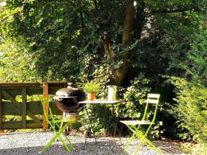 a table and two chairs and a grill in a yard at Vintage chalet in a very beautiful landscape in Aywaille