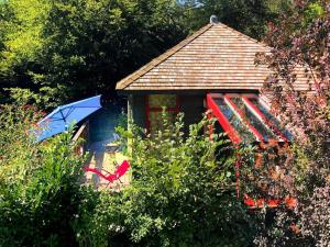 a small house with an umbrella and a chair at Vintage chalet in a very beautiful landscape in Aywaille