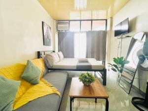 ein kleines Wohnzimmer mit Sofa und Tisch in der Unterkunft Complete Amenities Cozy Studio with Balcony in Naga