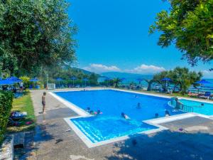 una grande piscina con persone in acqua di Manto On The Beach Apartments a Barbati