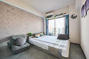 a bedroom with a bed and a chair and a window at Cyber Shinjyuku Tokyo Room in Tokyo