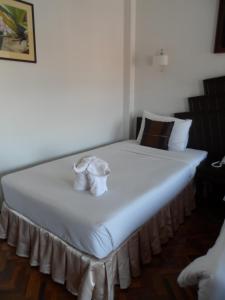 duże białe łóżko z dwoma białymi ręcznikami w obiekcie Baiyoke Chalet Hotel w mieście Mae Hong Son