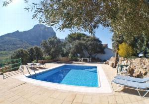 a swimming pool with two lounge chairs next to it at Conjunto El Carramolo in El Gastor