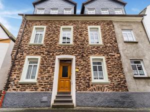 a brick building with a yellow door on it at Moselle River Retreat in Ediger-Eller