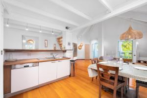 a kitchen and dining room with white cabinets and a table at LOFT COSY SUR MER in Filaos