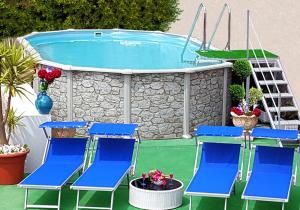 a group of blue chairs and a swimming pool at Casa Vacanza Villa Lesto in Barano d'Ischia