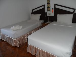 dos camas sentadas una al lado de la otra en una habitación en Baiyoke Chalet Hotel en Mae Hong Son