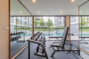 a gym with chairs and a swimming pool at C227 Brand New Condo Near Top Phuket Beach Clubs in Laguna Phuket