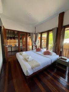 ein Schlafzimmer mit einem großen Bett in einem Zimmer mit Fenstern in der Unterkunft Ban Tha Ton Do Koh Yao noi in Ko Yao Noi + 44 Fotos