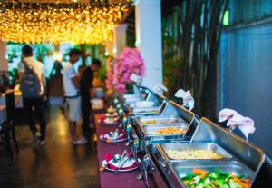 a buffet line with trays of food on it at Angkor Land House in Phumĭ Réach Born +250 photos
