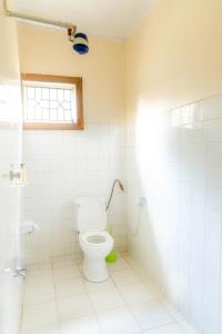 a bathroom with a toilet and a window at Arusha backpackers homes in Arusha