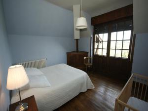 a bedroom with a bed and a lamp and a window at Elegant Mansion Stay in Belvès in Belvès