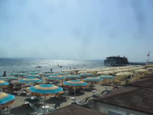 grupa parasoli i leżaków na plaży w obiekcie Parri Apartment w mieście Follonica