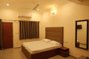 a small bedroom with a bed and a mirror at Hotel Times Stay in Udaipur