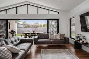 a living room with a couch and a table at Luxury On Lakeside in Mount Beauty