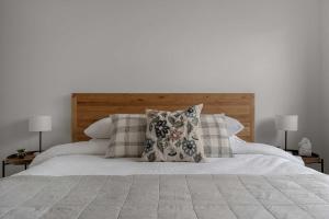 a white bed with two pillows and two lamps at Luxury On Lakeside in Mount Beauty