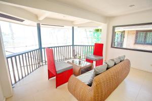 a living room with red chairs and a glass table at La Suerte Villa in Boracay +29 photos